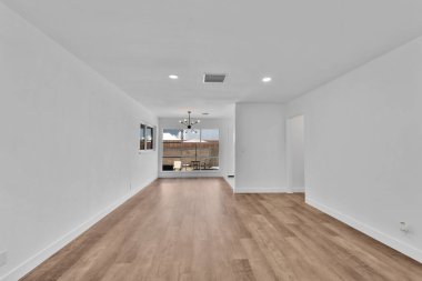 Beyaz duvarları ve geniş penceresi olan modern bir apartman dairesi.