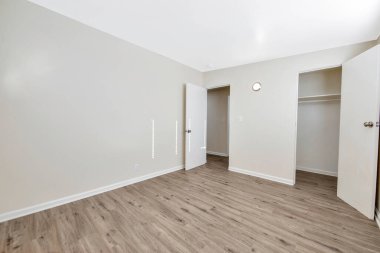 Ahşap zemini olan boş, modern bir apartmanın içinde.