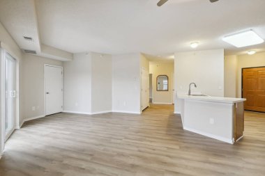 Beyaz duvarları ve ahşap zemini olan boş bir oturma odası.