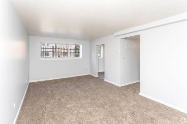 Boş ve mobilyasız yeni bir daire, beyaz duvarlı büyük boş bir yatak odası, büyük parlak pencereler. İçeride kimse yok. Kaliforniya, ABD - 2023