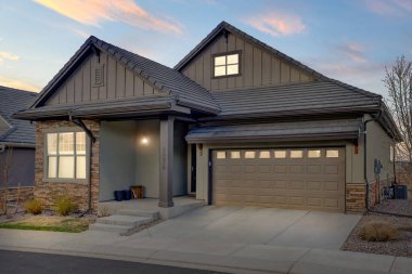 Yeni inşa edilmiş lüks evin güzel dış görünüşü. Yeşil çimenli bahçe ve yürüyüş yolu süslü bir şekilde tasarlanmış verandaya ve ön girişe çıkıyor. Florida, ABD