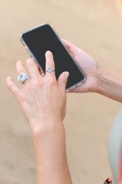 Meksika 'da yaz gezisi sırasında el ele tutuşan ve boş akıllı telefonları işaret eden isimsiz bir kadının yüksek açılı görüntüsü.