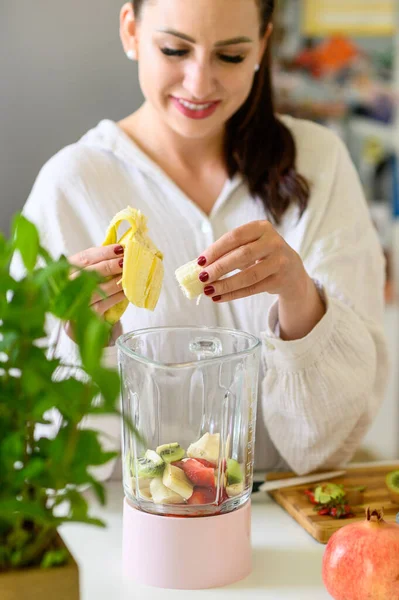 Pozitív Fiatal Fehér Inges Mosolyog Friss Banánszeleteket Tesz Átlátszó Turmixgépbe — Stock Fotó