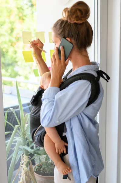 Concentrated Young Female Freelancer Casual Shirt Baby Talking Smartphone Writing — Stock Photo, Image