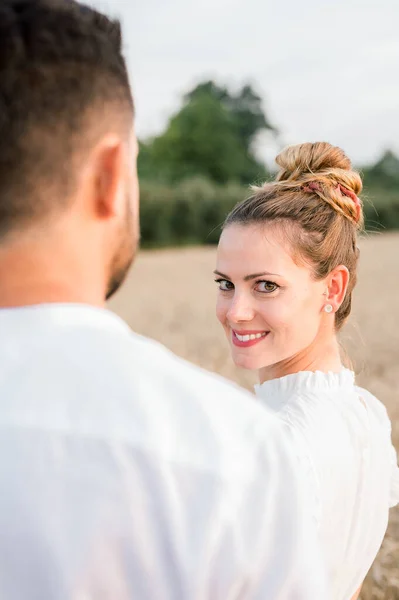 回头看 一个难以辨认的男人 带着快乐的白衣妻子 一边站在田里 一边望着对方 一边呆在一起 — 图库照片