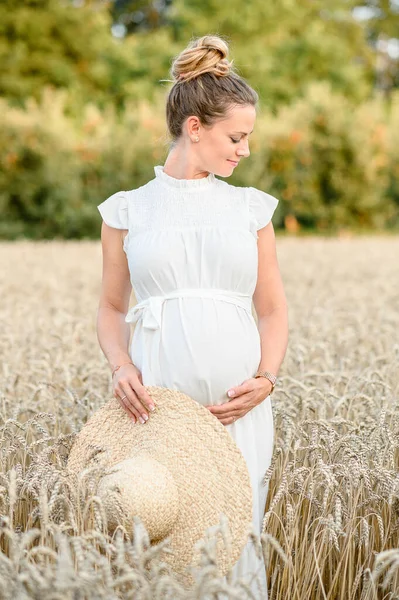 Hasır Şapkalı Beyaz Elbiseli Gülümseyen Genç Bir Kadın Bebek Çarpması — Stok fotoğraf