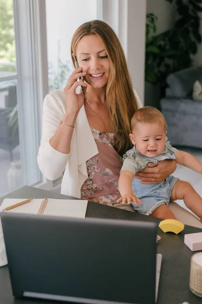 Ung Multitasking Kvinne Arbeider Snakker Telefonen Mens Holde Liten Baby – stockfoto