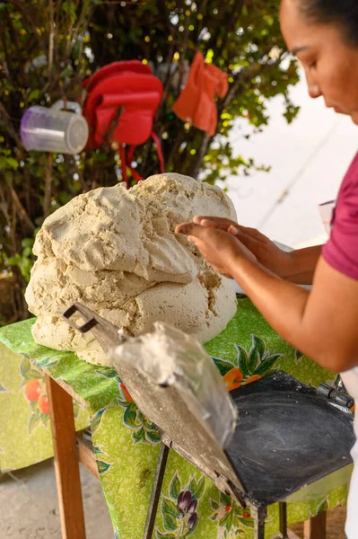 stock image Side view of female cook flattening tortilla dough on press machine at market stall