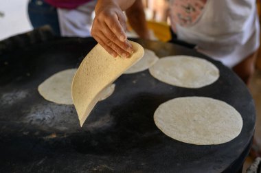 Yüksek ekin açılı, isimsiz kadın aşçı el yapımı tortilla pişiriyor.