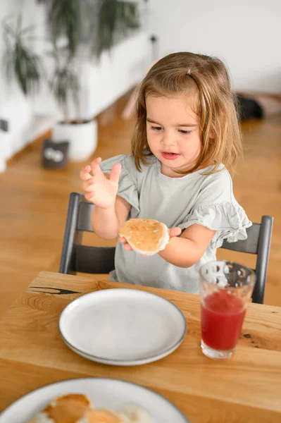 Милая Маленькая Девочка Сидит Деревянным Столом Ест Вкусный Завтрак Блины — стоковое фото