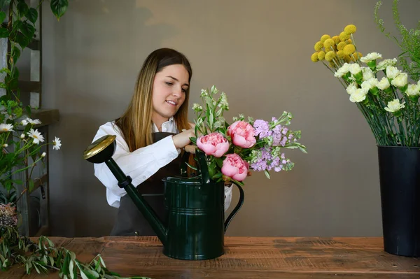 Positive Young Female Florist Apron Standing Wooden Counter Arranging Bouquet — Stockfoto