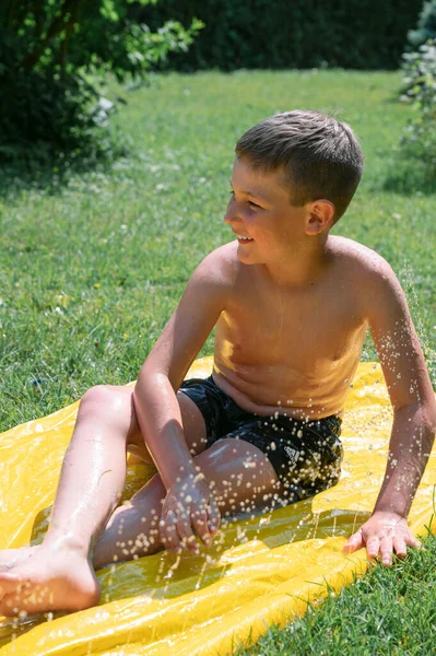 Widok Boku Chłopca Bez Koszulki Mokrymi Włosami Rozpryskujące Wodę Podczas — Zdjęcie stockowe