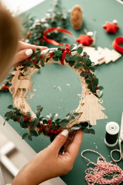 Noel çelengi manzaralı, düz bir yer. El ele tutuşan çelenkler, dallar, böğürtlenler, kozalaklar ve yeşil arka planda izole edilmiş şeritler. Noel Taç Atölyesi. Noel arkaplanı. 