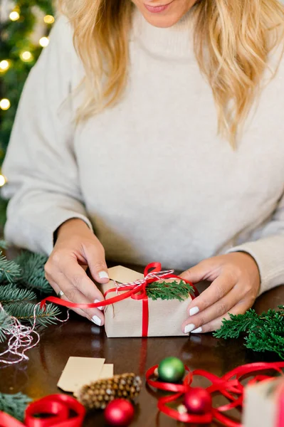 Noel hediyesini elinde süveter içinde elinde kırmızı kurdele ve elinde köknar olan tanınmamış bir kadın mahsulü. Noel ve Yeni Yıl Konsepti