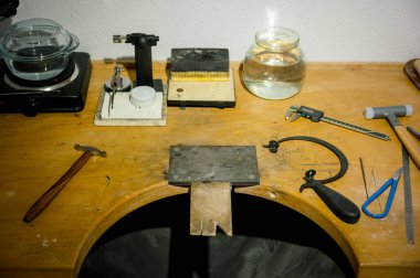 Kuyumcu işyerindeki farklı kuyumculardan. Mücevher işinde çalışan bir kuyumcu. Profesyonel aletlerle mücevher yapımı için bir masaüstü. iş kavramı