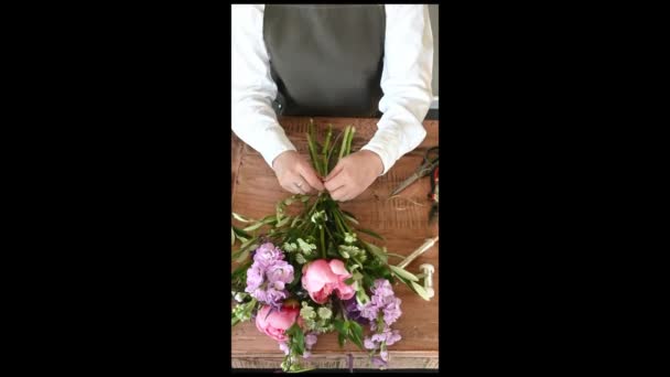 쾌활한 꽃집에서 앞치마에 테이블에 감싸는 향기로운 무리에서 — 비디오
