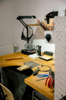 Mücevher işyerindeki farklı kuyumcuların yan görünüşü. Mücevher işinde çalışan bir kuyumcu. Profesyonel aletlerle mücevher yapımı için bir masaüstü. iş kavramı