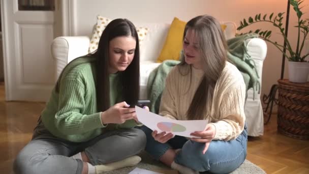 Focused Young Woman Reviews Document Her Friend Both Sitting Comfortably — Stock Video