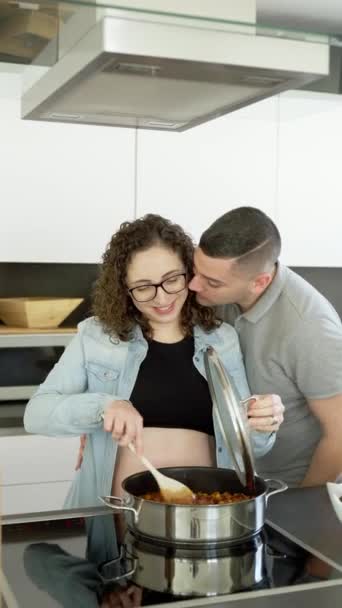 一对穿着休闲装 站着在厨房做饭的怀孕年轻夫妇的竖直照片 — 图库视频影像