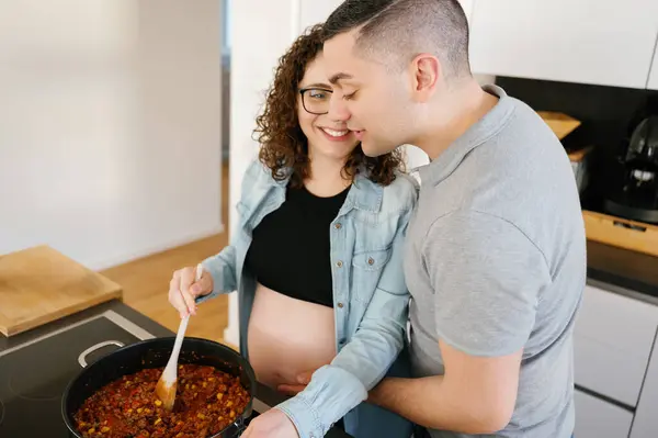 Mujer Embarazada Cocinando Mientras Marido Abraza Casa — Foto de Stock