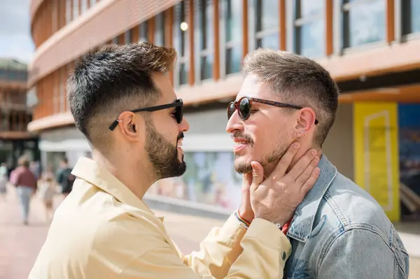 Genç çift dışarıda duruyor, sarılıyor, sarılıyor, öpüşüyor, mutluluk duygularını gösteriyorlar. LGBT gay çifti mutluluk anlarını sever