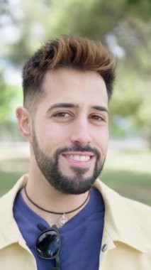 Sakallı, sıradan giyinmiş, dışarıda kameraya bakıp gülümseyen genç ve yakışıklı bir adam. Yaşam tarzı ve insan konsepti