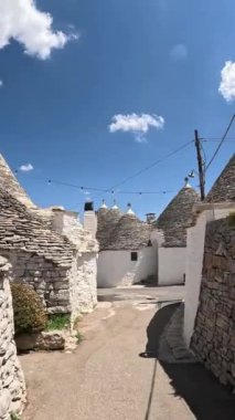 Dar kaldırım taşlı sokaklar ve Arbelobello 'daki taş trulli evler. Taşlar çatıları işaret etti ve güneşli bir günde tuğladan evler beyazlattı. seyahat kavramı