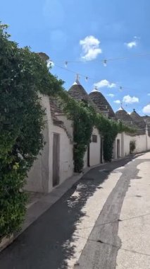 İtalya 'nın Puglia kentindeki Arbelobello köyünde eski, geleneksel trulli evler. Güneşli bir günde şehri gezmek, turizm, seyahat ve tatil konsepti