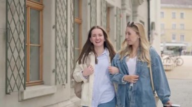 Avrupa 'da tatil boyunca valiz taşıyan beyaz tenli iki kadın turist..