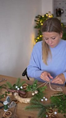 winter holidays, diy and hobby concept - close up of happy smiling woman with decorative rope making christmas wreath at home