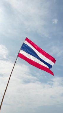 Geniş mavi gökyüzüne ve yumuşak beyaz bulutlara karşı dalgalanan nazikçe dalgalanan Tayland ulusal bayrağı kültürel mirası ve ulusal gururu sembolize ediyor.