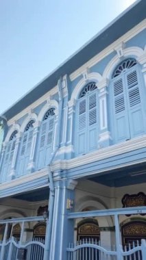 Geleneksel sino-Portekiz mimarisi, mavi kepenkleri ve süslü ayrıntılarıyla büyüleyici bir evin yer aldığı Tayland 'ın eski Phuket kasabasında parlıyor. seyahat kavramı