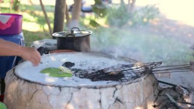Şef otantik Meksika sokak yemeklerini geleneksel Comal üzerine hazırlıyor, mısır tortillalarını ateşin üzerine dikkatlice yerleştiriyor, canlı açık havada zengin dumanlı aroma yaratıyor.