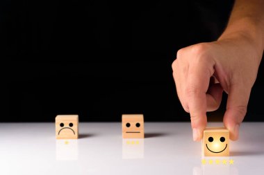 Müşteri hizmetleri ve memnuniyet geri bildirim konsepti, iş adamları gülen tahta küple gülen surat ile geri bildirim gösteriyorlar. Ahşap küplerin derecesi. ahşap küp fikirleri.