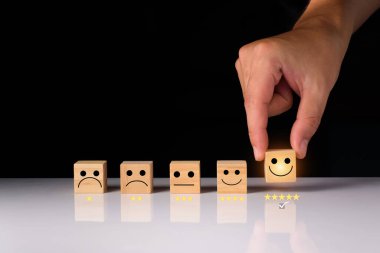 Müşteri hizmetleri ve memnuniyet geri bildirim konsepti, iş adamları gülen tahta küple gülen surat ile geri bildirim gösteriyorlar. Ahşap küplerin derecesi. ahşap küp fikirleri.