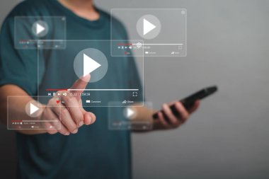 Akıllı telefonlu çevrimiçi film yayını. İnsanlar cep telefonundan hayali bir video oynatıcı servisi ile film izliyorlar. Çevrimiçi video oynatılıyor, çevrimiçi yayın. Çevrimiçi platformlarda videolar aranıyor.