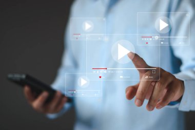 Akıllı telefonlu çevrimiçi film yayını. İnsanlar cep telefonundan hayali bir video oynatıcı servisi ile film izliyorlar. Çevrimiçi video oynatılıyor, çevrimiçi yayın. Çevrimiçi platformlarda videolar aranıyor.