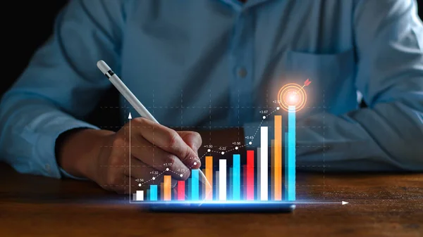 Business analysis, company profits. Businessman analyzing profit chart trends, making investment plans, trading stocks, economic trends, setting future goals. On a digital graph data display tablet.