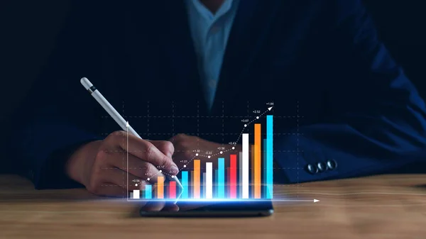 Business analysis, company profits. Businessman analyzing profit chart trends, making investment plans, trading stocks, economic trends, setting future goals. On a digital graph data display tablet.