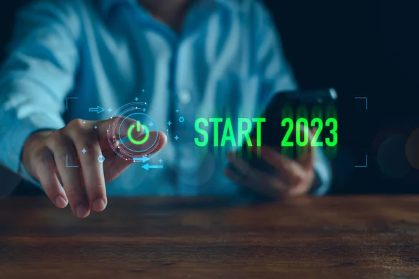 Businessman touching on virtual screen start button for 2023 New Year, Start new year 2023 with goal plan, goal concept, action plan, strategy, new year business vision. new start up business.