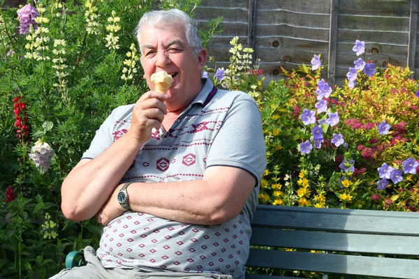 Пожилой Пожилой Человек Сидит Своем Саду Удовольствием Ест Мороженое Улыбаясь — стоковое фото