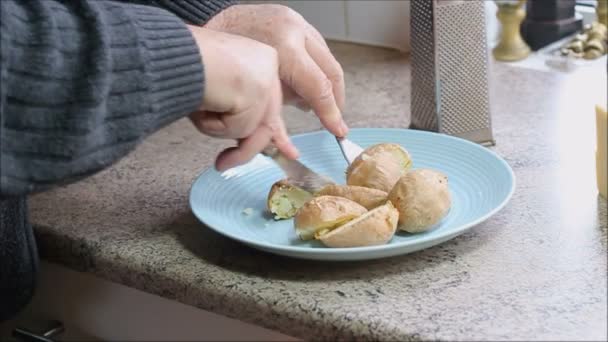 皿の上の皮で焼きジャガイモを切り取る 昼食の準備 — ストック動画