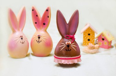 Hafif arka planda, etekli, paskalya tavşanları, iki ev.