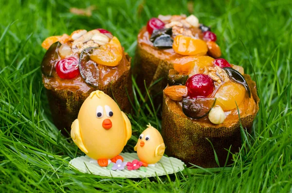 Üç paskalya keki ve çimenlerde bir tavuk şekeri.