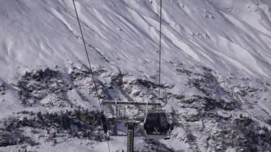 Obergurgl, Tyrol, Avusturya - 22 Ocak 2023: Karlı Obergurgl kayak merkezindeki teleferiklerin altından el kamerası görüntüsü. Tyrol, Avusturya 'daki Tztal Alpleri' nde yer alan köy.
