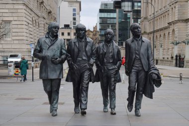 Liverpool, Merseyside, Birleşik Krallık - 12 Mart 2023: Liverpool 'un ikonik bronz heykeli The Beatles Heykeli listelenen Three Graces binalarının önündeki rıhtımın başındadır. Popüler Fab Four cazibesi