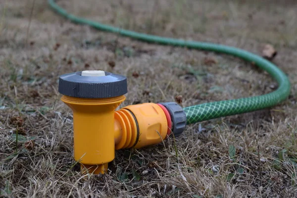stock image Close up of a garden hose sprinkler lying unused on unkept dry, unhealthy grass. UK drought, hosepipe ban.