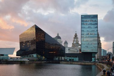Liverpool, Merseyside, Birleşik Krallık - Ekim 12021: Arkaplanda ünlü Liverpool binası ile günbatımında konserve limanı.