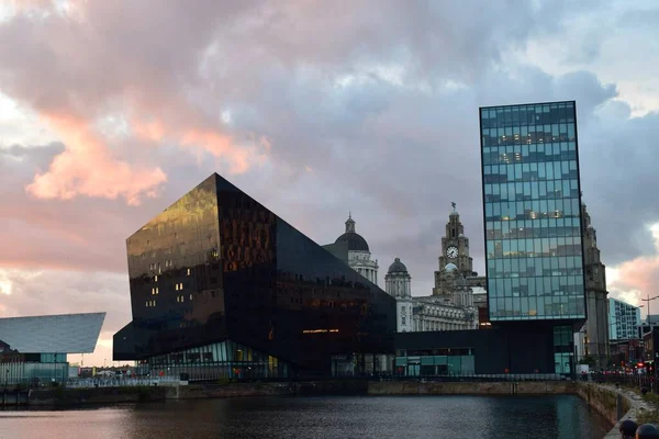 Liverpool, Merseyside, Birleşik Krallık - Ekim 12021: Arkaplanda ünlü Liverpool binası ile günbatımında konserve limanı.