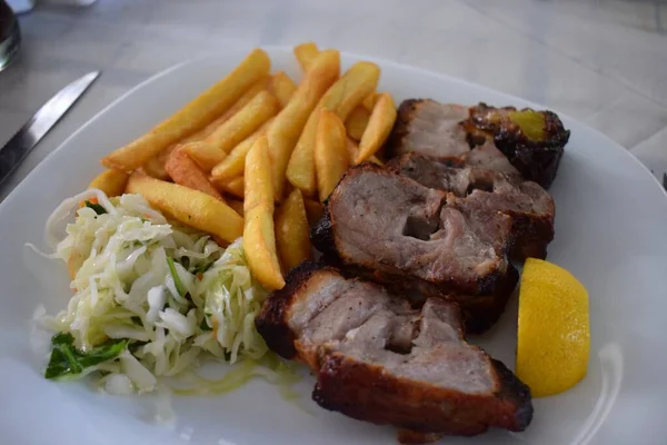 新鮮なギリシャ料理のプレート チャーシューとサラダ付きのオープンロティスリーオーブンでゆっくりと調理されたポークベリー — ストック写真